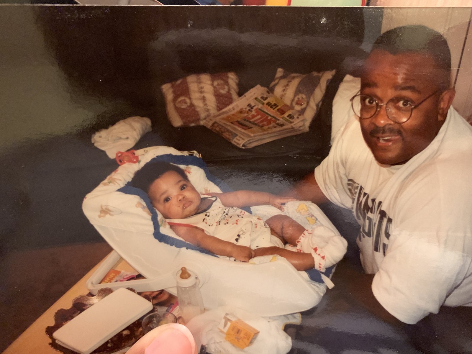 Michael Gaiter with his baby daughter beside a bouncer seat