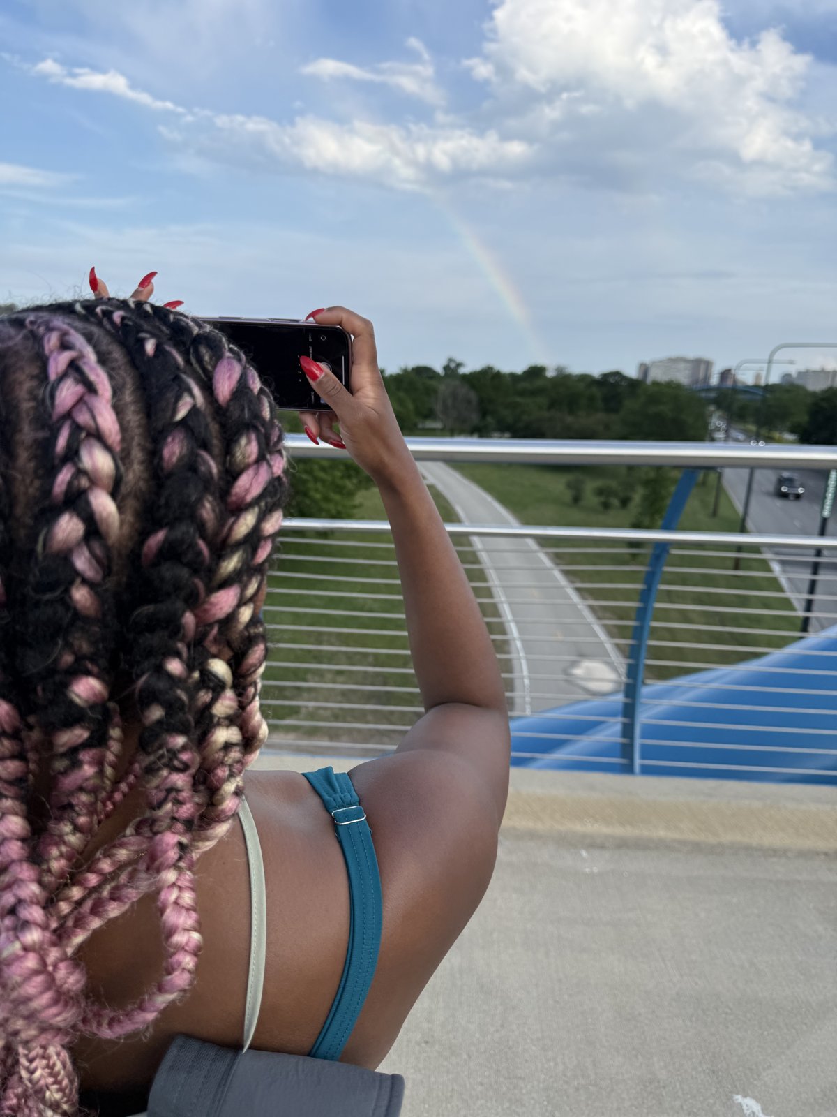 Gabriell photographing a rainbow from a bridge